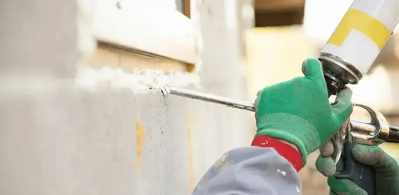 Handyman sealing exterior gaps with caulk for weatherproofing in Bakersfield, CA