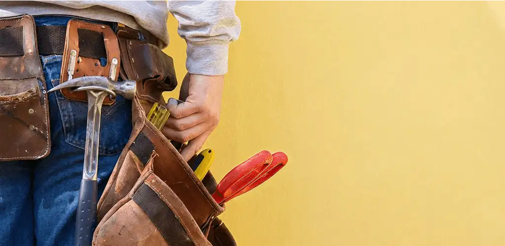 Handyman with tool belt ready for home repairs and maintenance in Bakersfield, CA