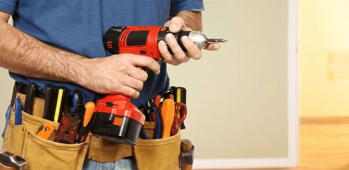 Handyman holding a power drill for home repairs and installations in Bakersfield, CA