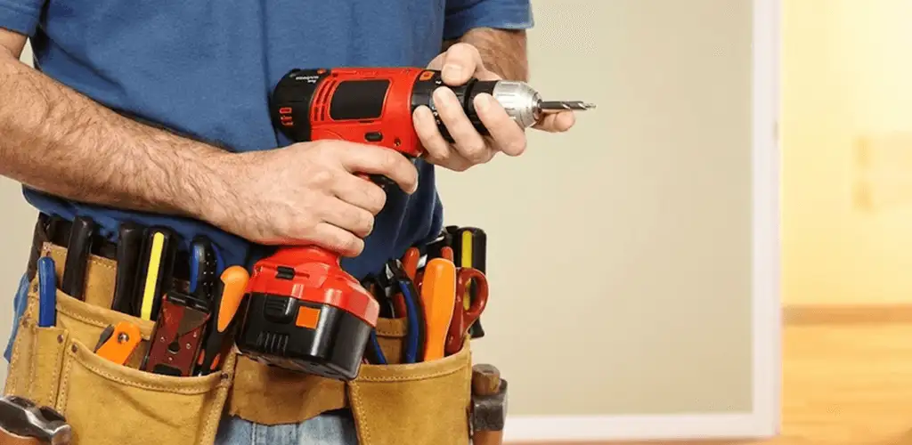Handyman holding a power drill for home repairs and installations in Bakersfield, CA
