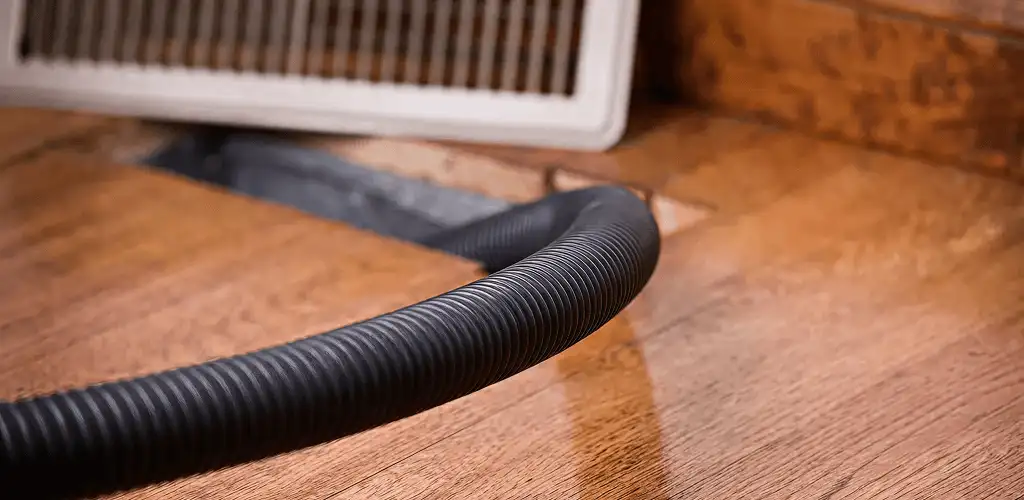 Air duct cleaning hose inserted into a floor vent for ductwork cleaning in Bakersfield, CA